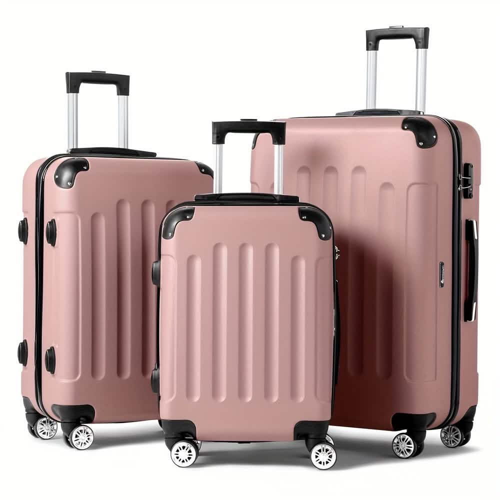 Three pieces of rose gold hardside luggage with black trim and telescoping handles stand upright against a plain white background.
