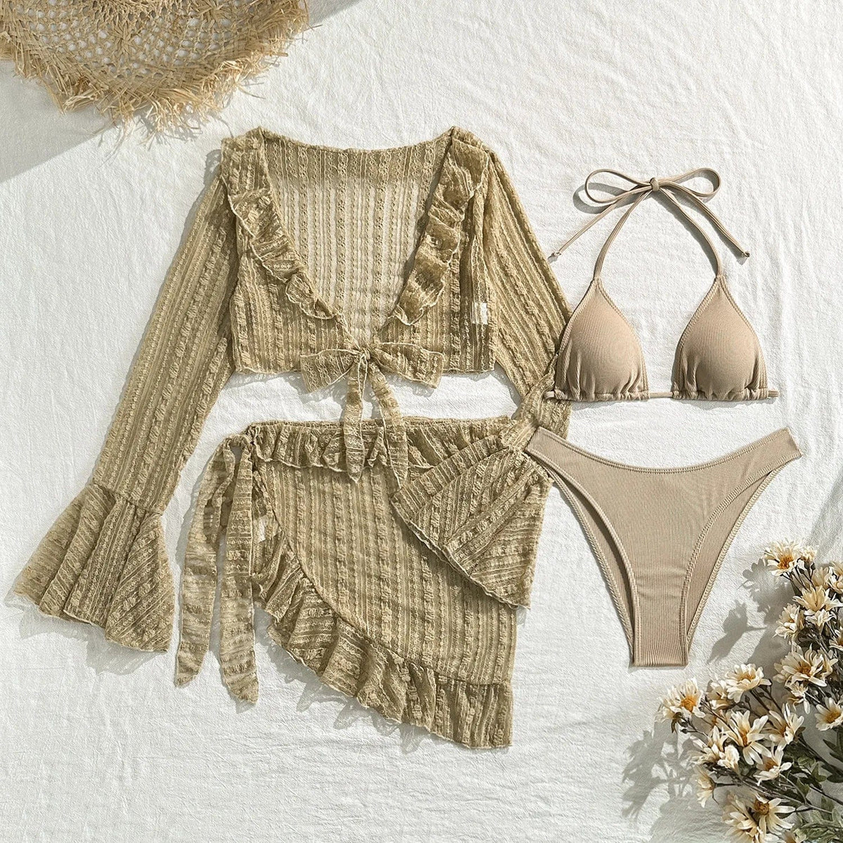 A beige three-piece swimsuit set featuring a triangle bikini top, high-cut bikini bottoms, and a long-sleeve, ruffled-edge sheer cover-up top and matching wrap skirt laid flat against a textured white background.