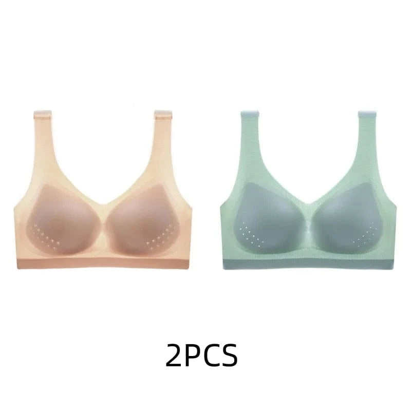 Two seamless sports bras with perforated detail on the cups, displayed in nude and light green colors.