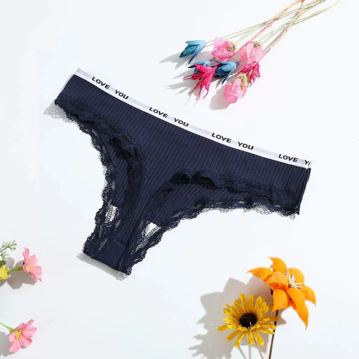 A pair of navy blue ribbed panties with a white waistband featuring the repeated text LOVE YOU and decorative lace trim along the leg openings, arranged on a white background with floral accents.