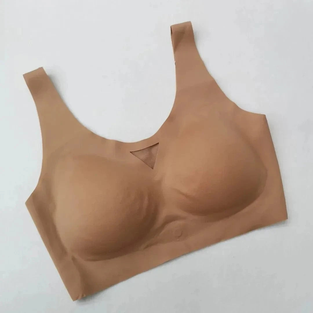 A beige seamless scoop-neck bra with molded cups and a small triangular mesh cutout detail at the center front.