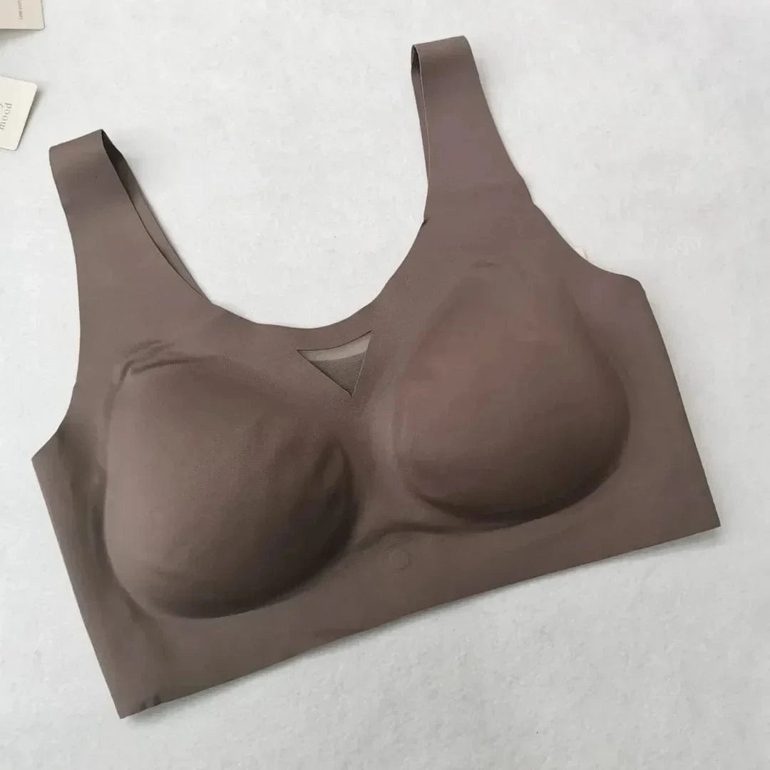 A seamless, taupe-colored wireless pullover bra with wide shoulder straps and a small triangular mesh cutout detail at the center of the neckline.