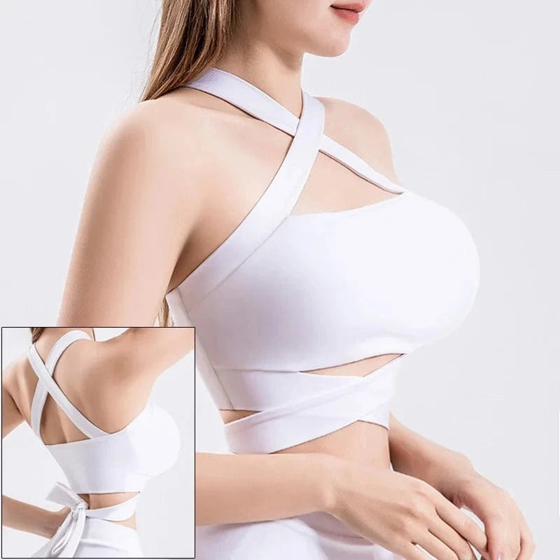 A white sports bra with a crossover halter neckline and a wraparound strap design featuring a tied bow closure at the lower back.