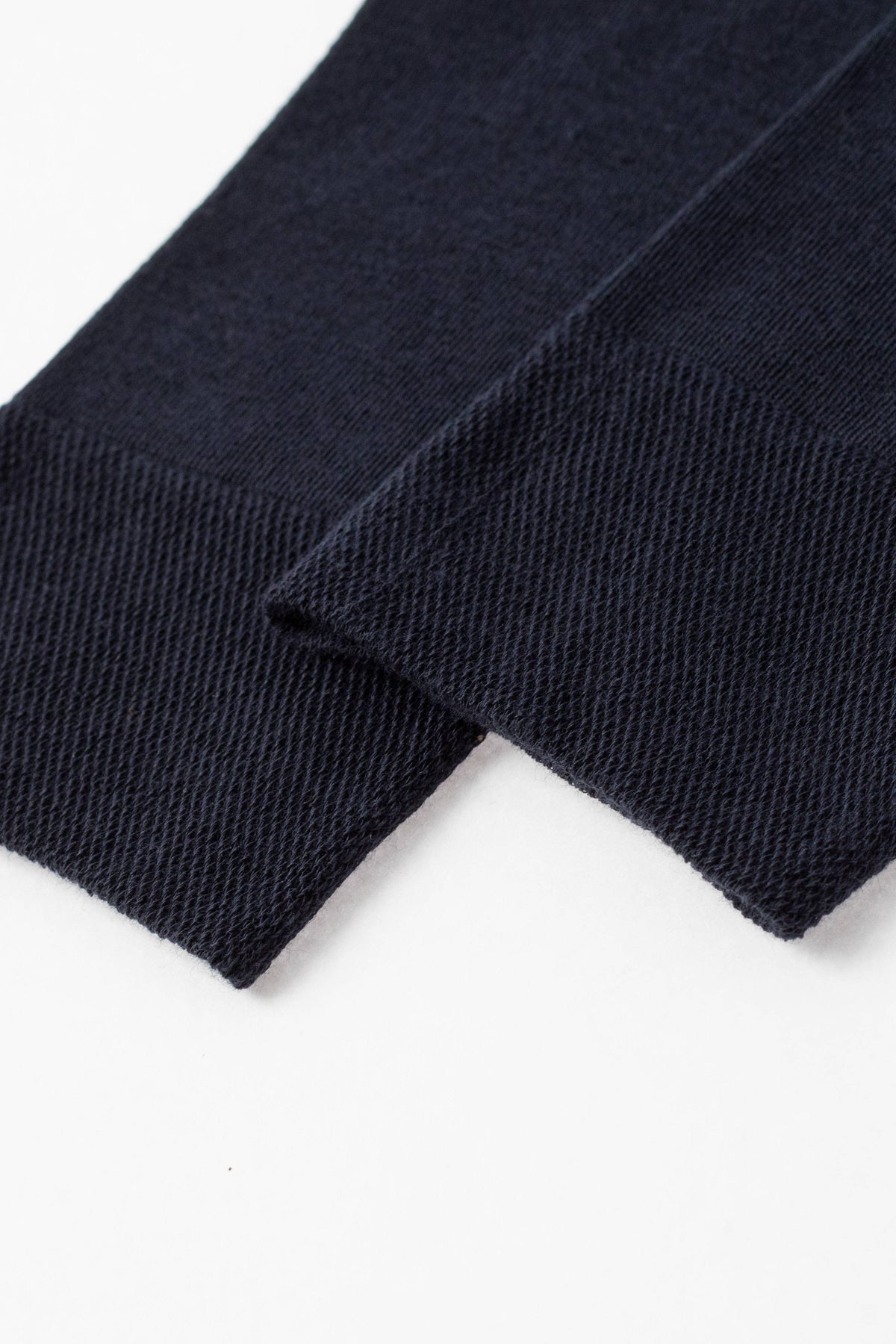 Two dark navy blue fabric cuffs featuring a fine, ribbed knit texture shown against a plain white background.