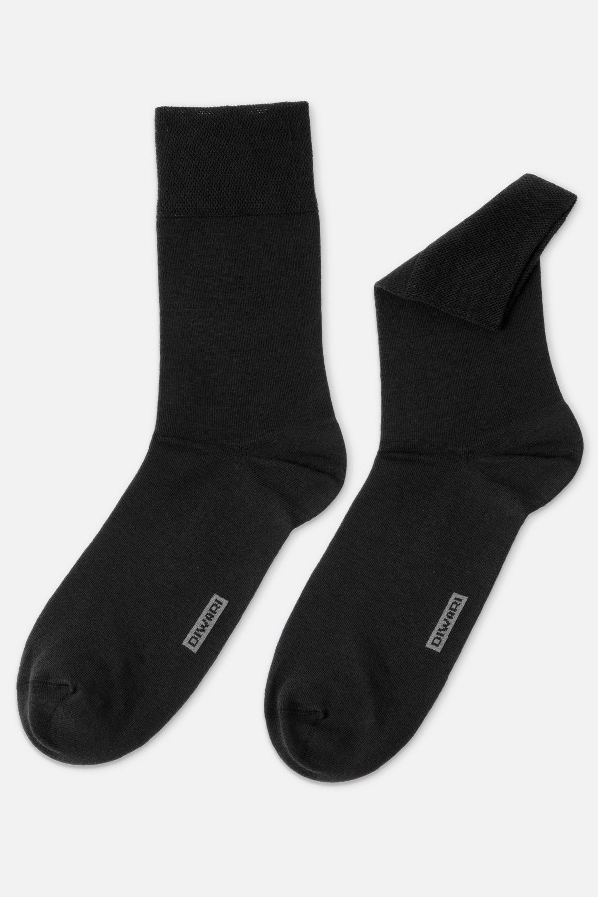 A pair of black crew socks positioned side-by-side against a plain background, one lying flat and the other slightly folded at the cuff, both featuring a grey brand logo on the top of the foot.
