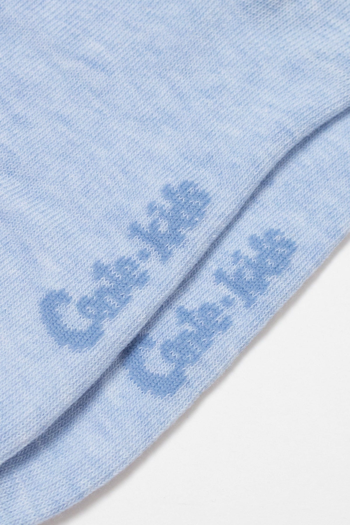 A close-up view of light blue fabric showing the brand name Cale-kids printed in a darker blue font across the bottom of the folded material.
