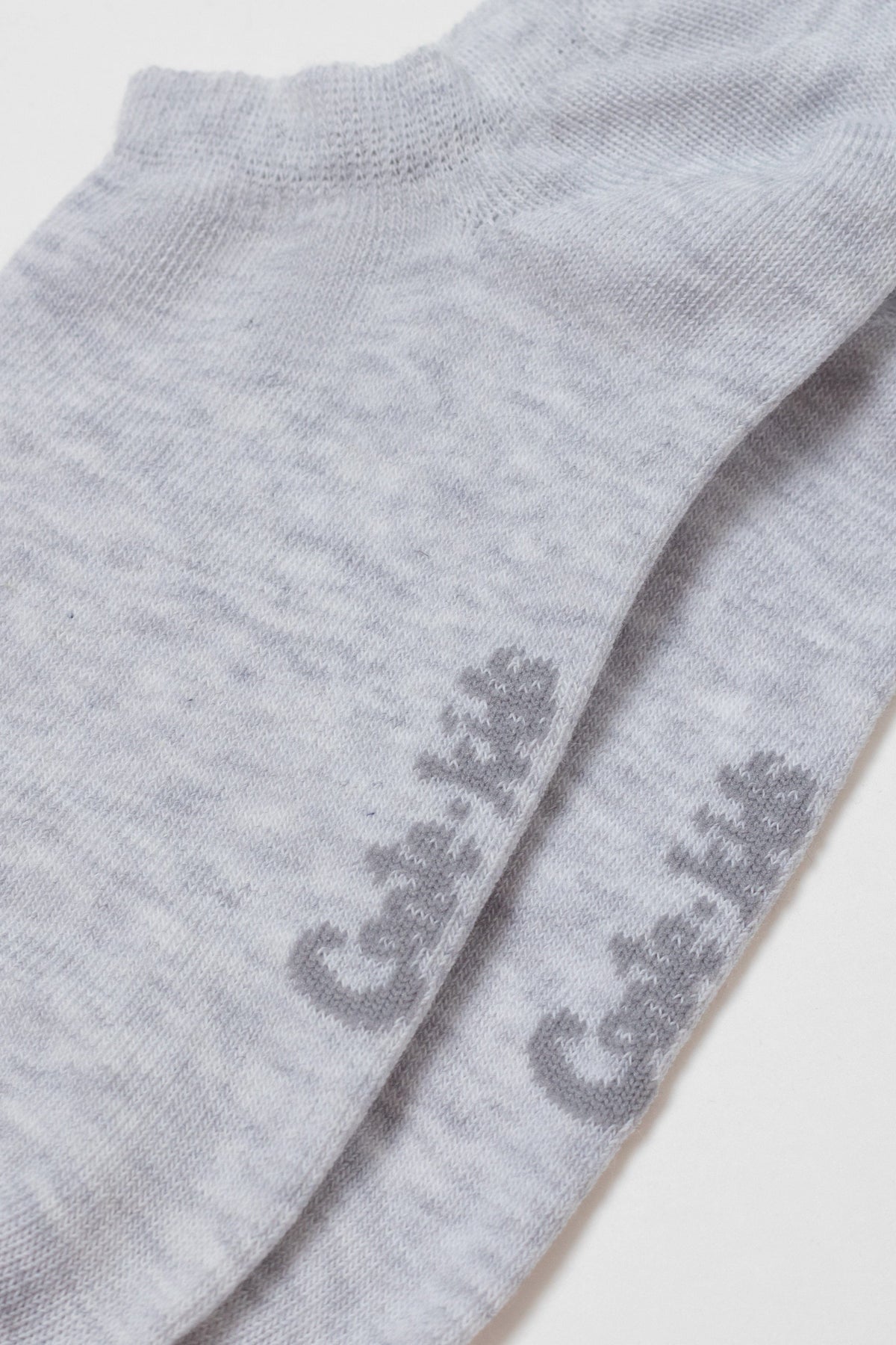 A pair of grey marl ankle socks featuring the words Cute Kids printed in a darker grey textured font on the side.