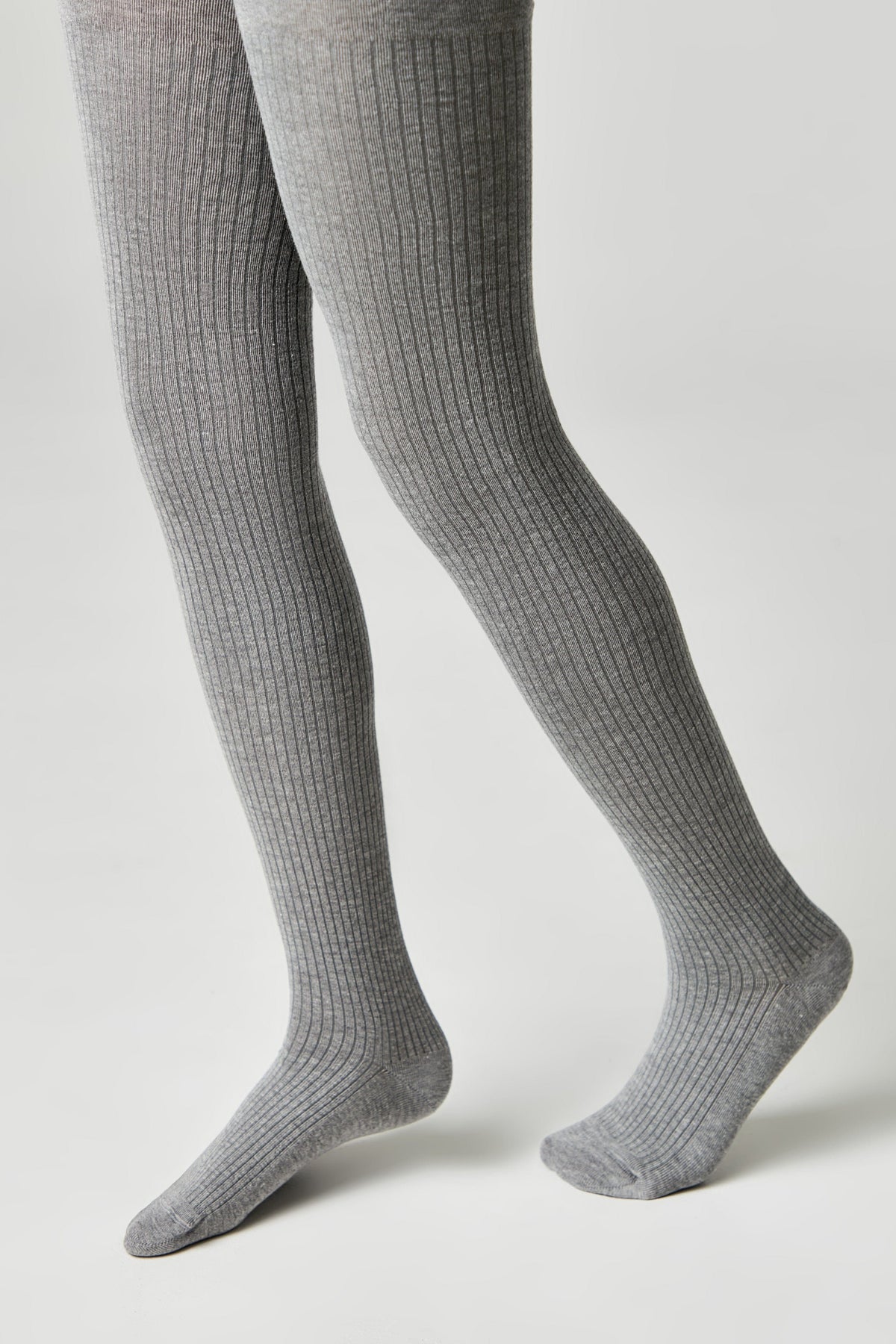 Gray ribbed tights worn on a person's legs against a solid light gray background.