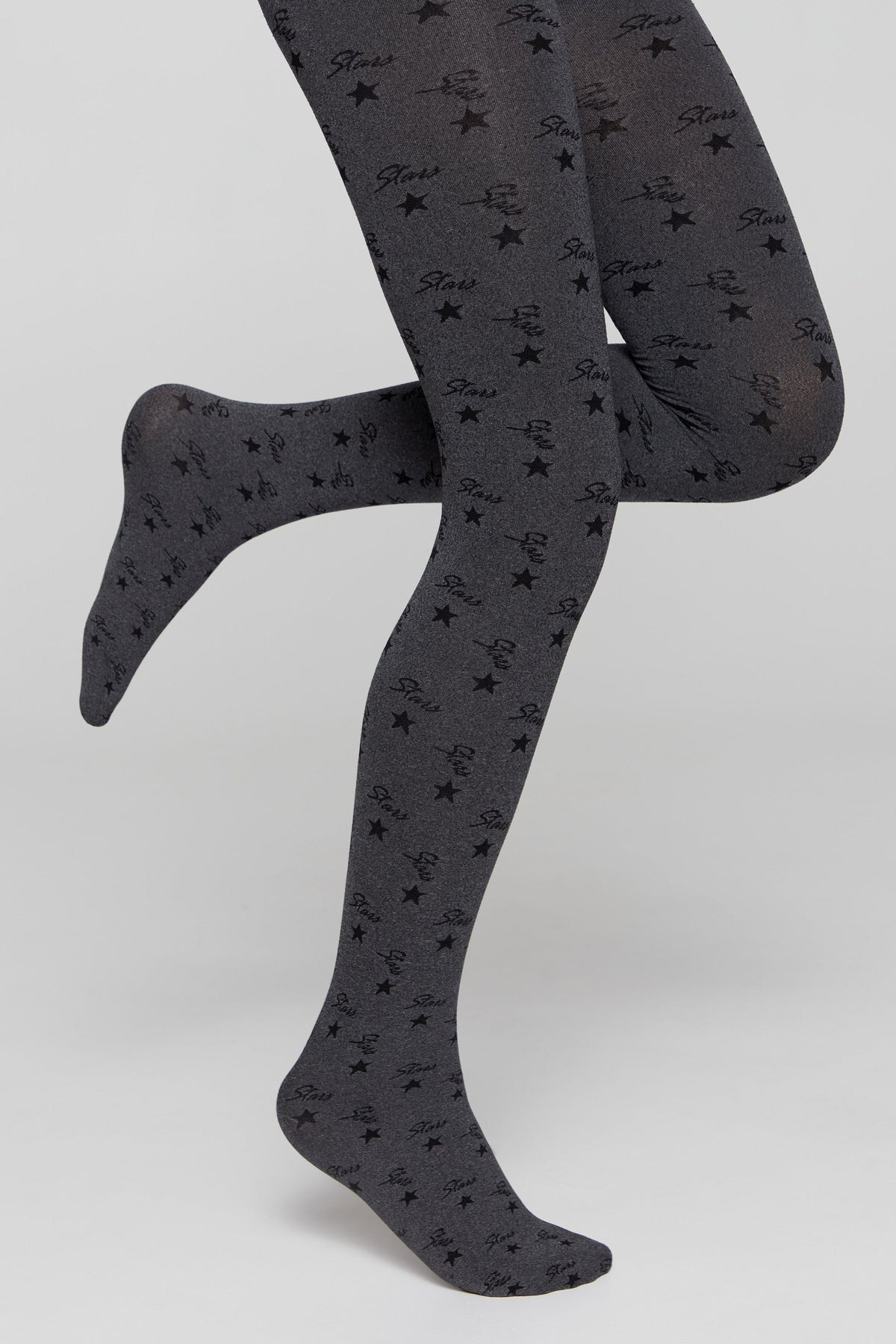 Dark grey tights patterned with scattered black stars and the repeating script text 'Stars' against a plain light background.