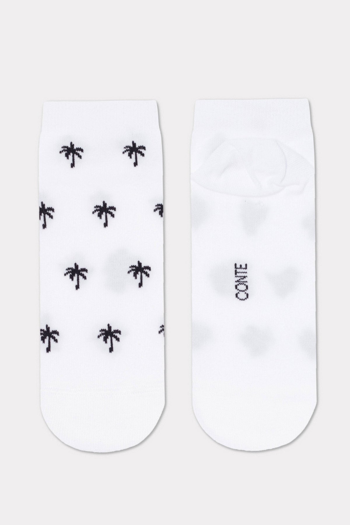 A pair of white ankle socks featuring a black palm tree pattern on the front and the text CONTE printed on the sole.