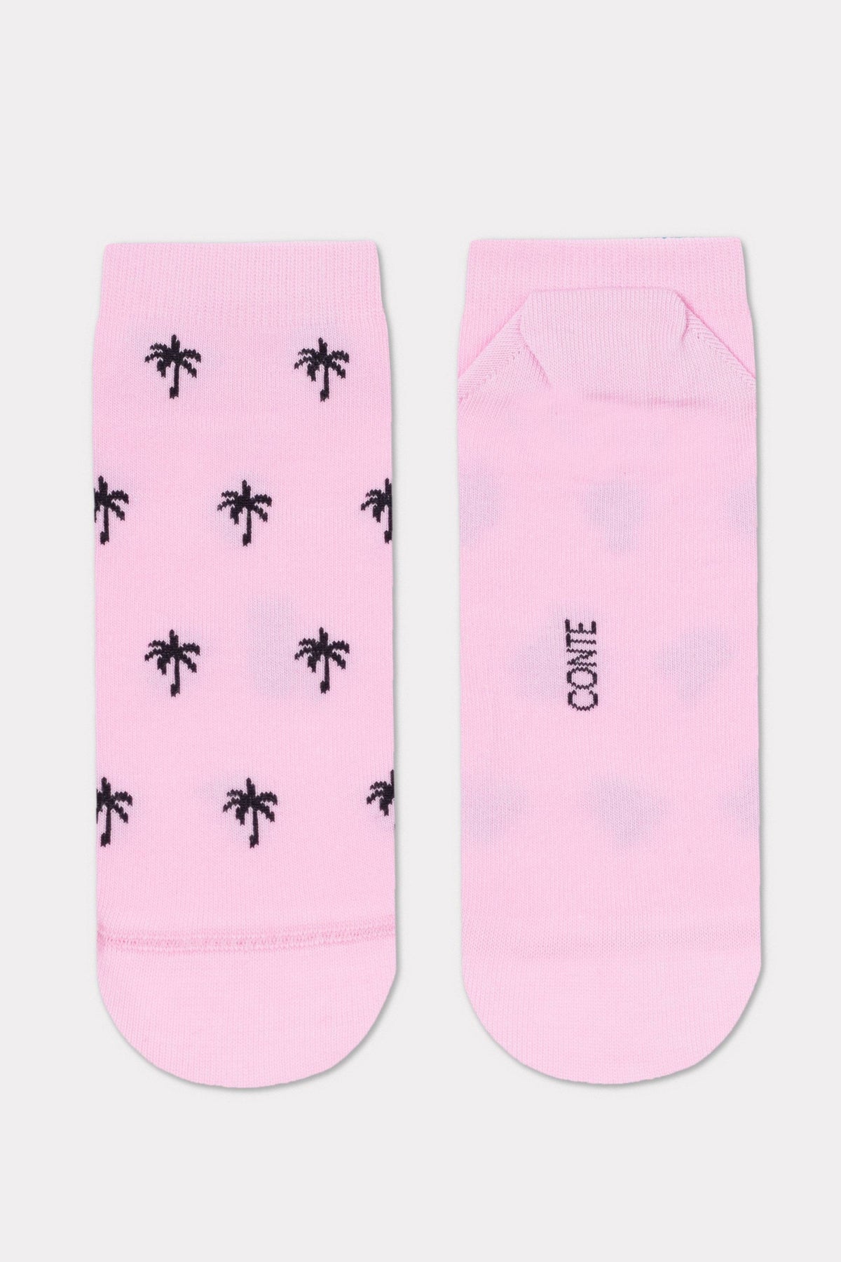 A pair of light pink socks featuring a repeating pattern of small black palm trees on the front and the word CONTE printed on the back.