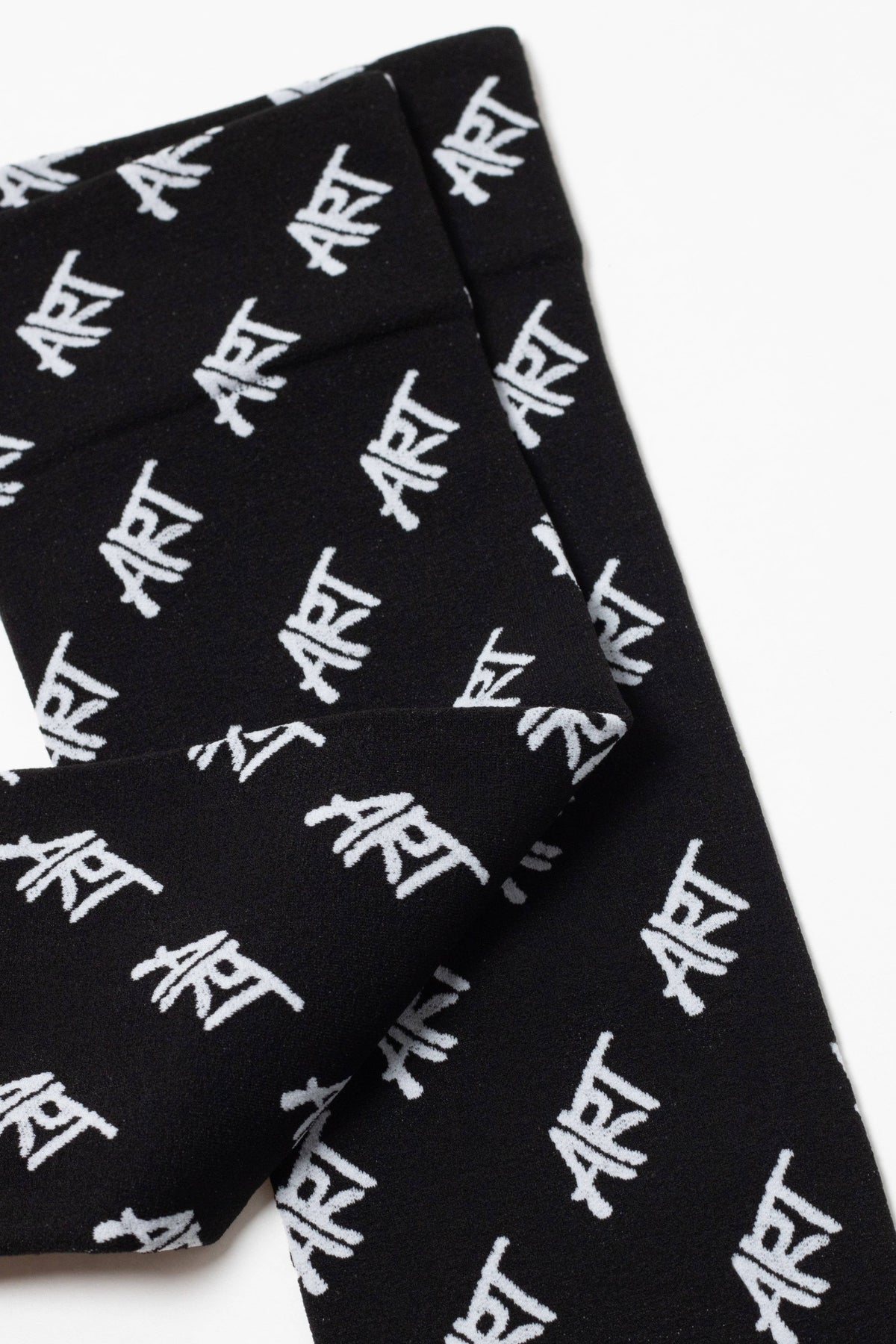 Black socks feature a repeating white graffiti-style text pattern spelling the word ART across the fabric.