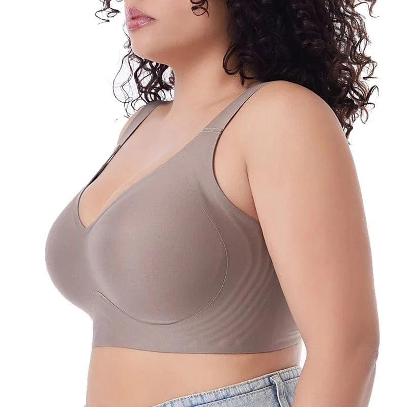 A side profile of a person wearing a seamless, taupe-colored full-coverage bra with a wide band and thick straps.