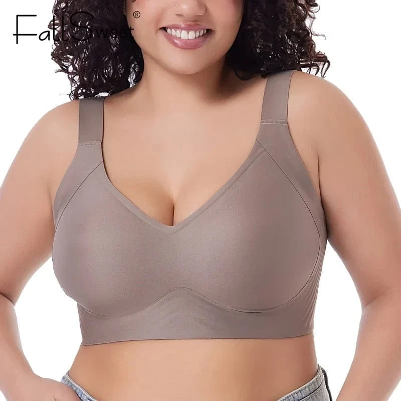 A person wears a taupe-colored, full-coverage wireless bra with wide shoulder straps and a smooth, minimalist design.