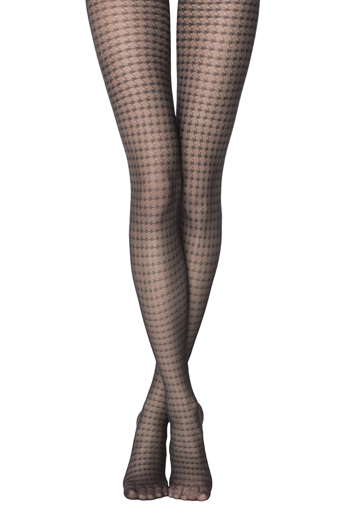 A pair of legs wearing black sheer patterned tights with a repeating houndstooth design against a white background.