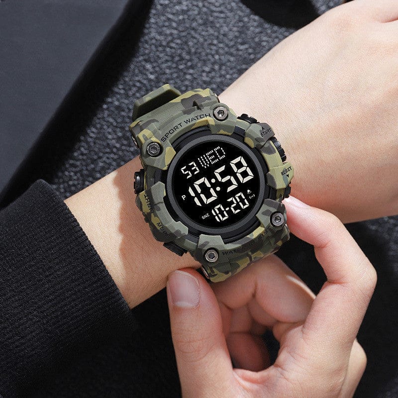 A camouflage-patterned digital sports watch is worn on a wrist, featuring a round black dial with a digital display showing the time, date, and day of the week.