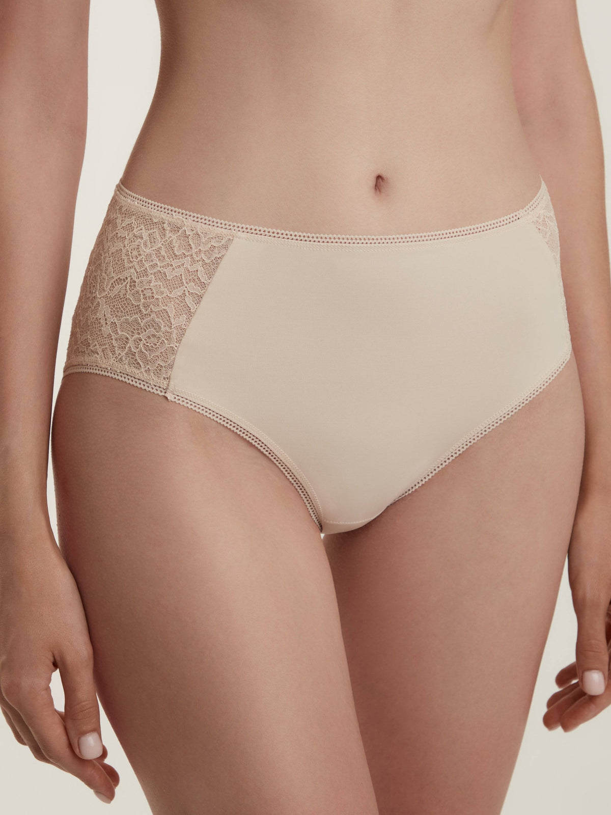 Beige high-waisted briefs featuring decorative lace side panels and a delicate stitched trim along the waistband and leg openings.