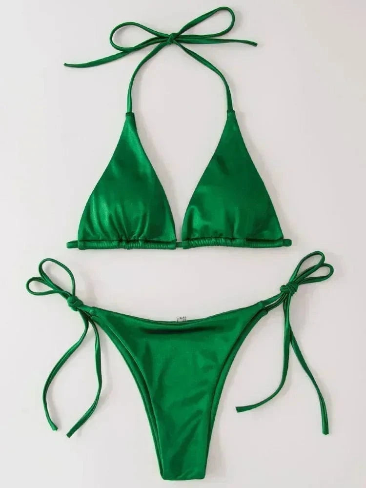 A vibrant green two-piece bikini set consisting of a triangle top with spaghetti straps and matching tie-side bottoms laid flat against a white background.