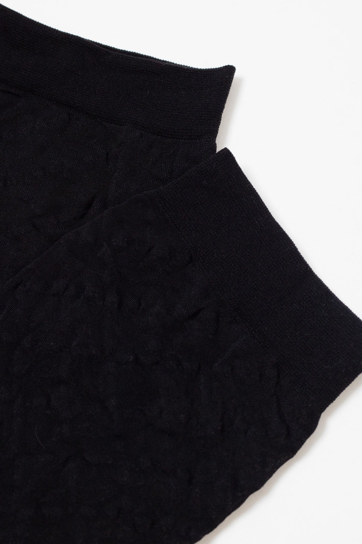 A pair of black, textured ankle socks shown from a top-down perspective.