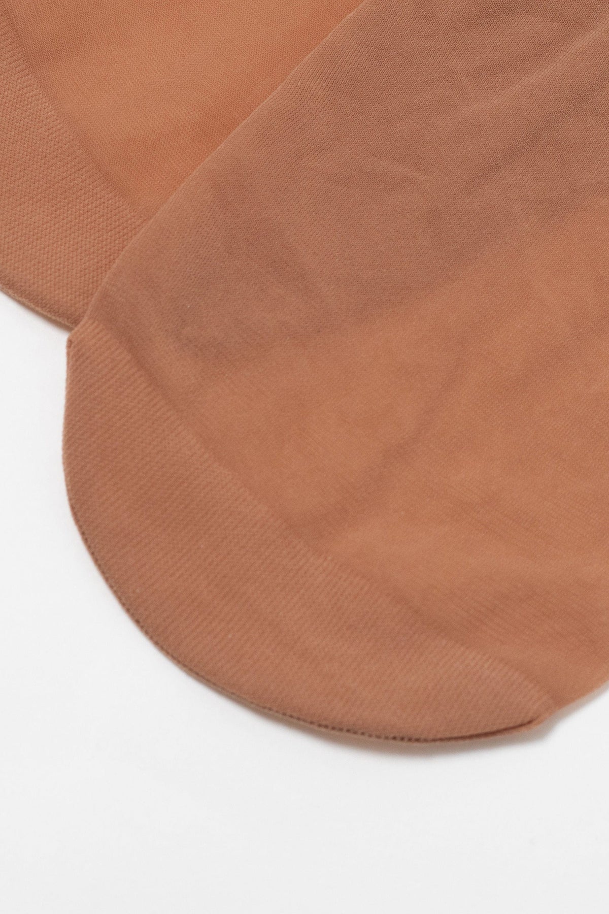 A pair of sheer tan-colored ankle socks laid flat on a white background.