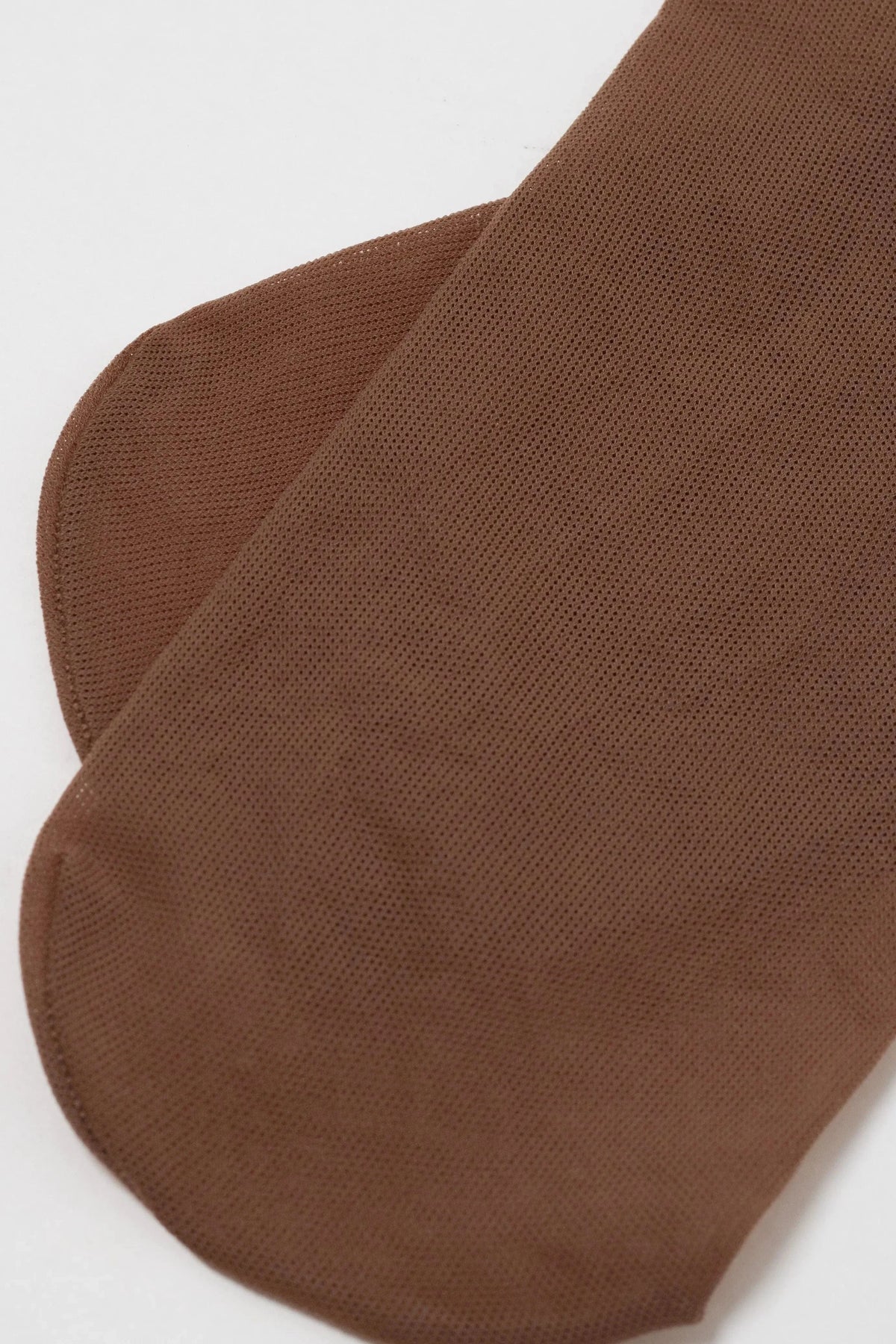 A pair of sheer brown hosiery socks laid flat against a plain white background.