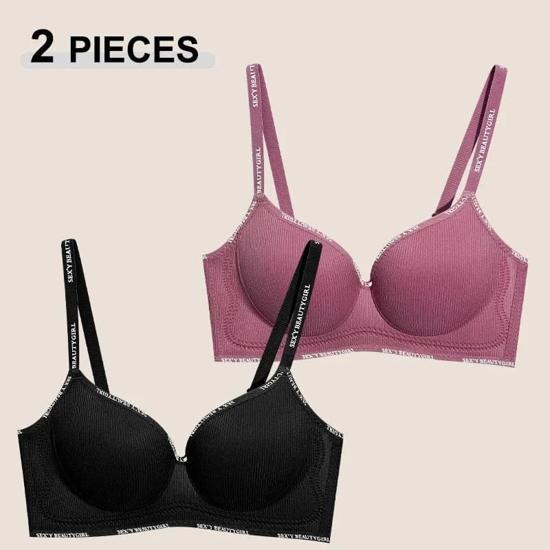 Two bras with ribbed texture and straps featuring text patterns are displayed against a plain background, one in black and the other in dusty rose.