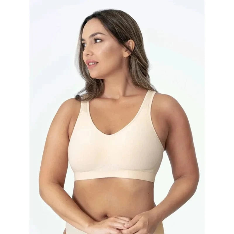 A woman wearing a beige seamless bralette with a V-neckline against a plain white background.