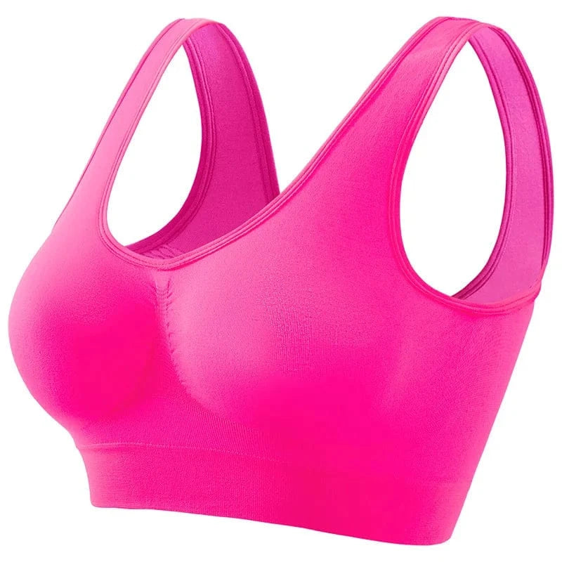 A bright neon pink seamless sports bra with wide straps and a textured ruched detail between the cups.