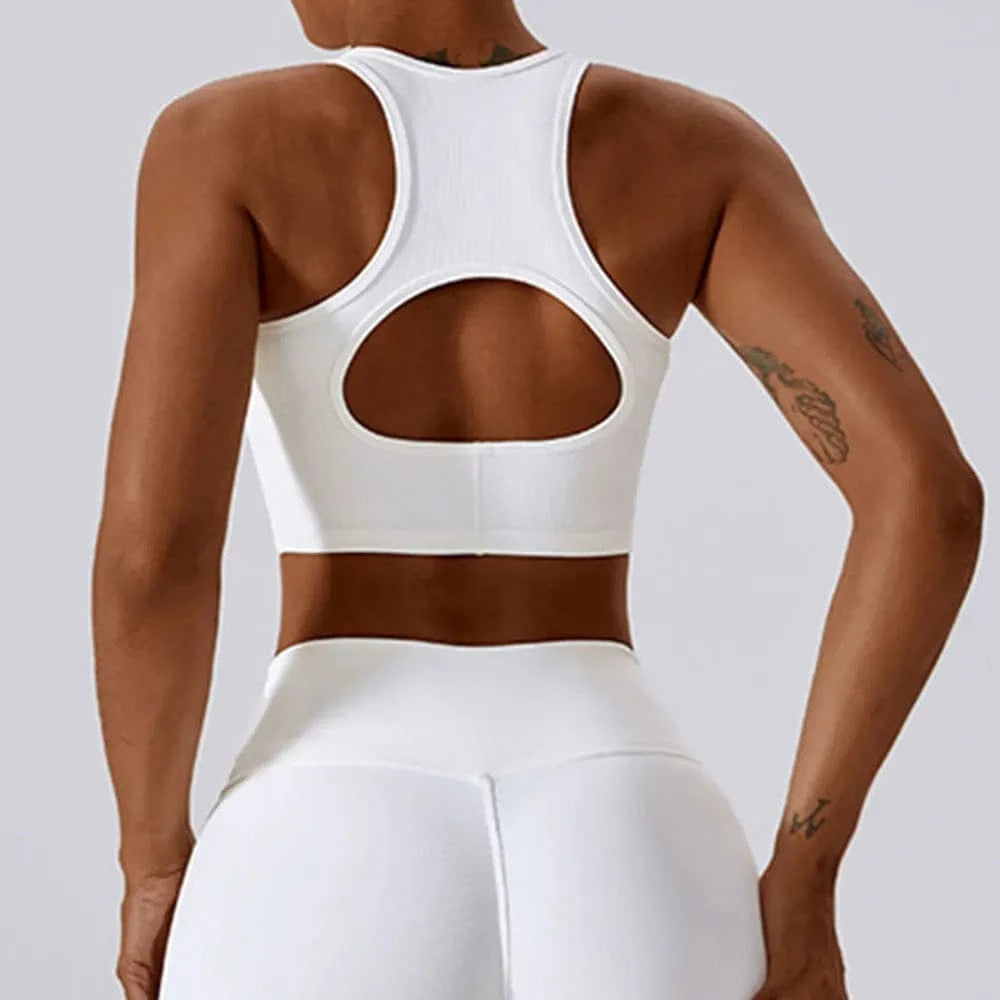 A white racerback sports bra with a circular cutout on the back, shown from behind on a person.