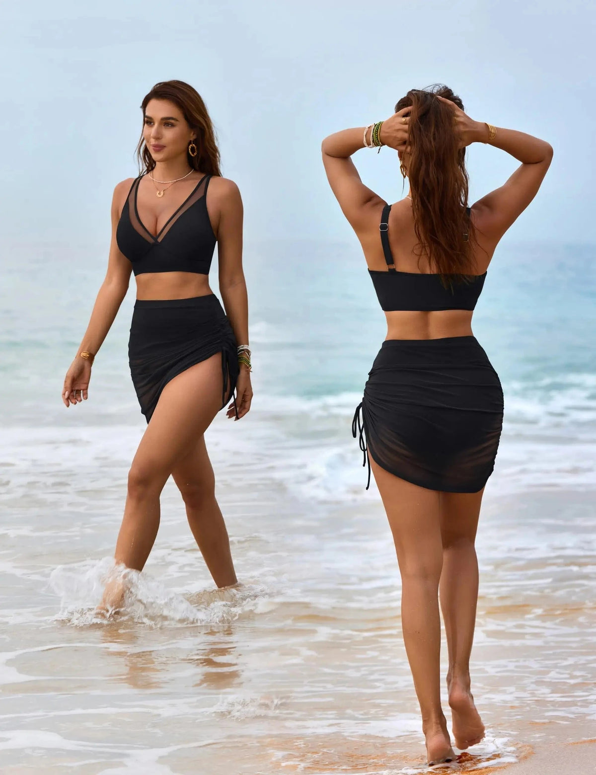 A two-piece black swimsuit featuring a mesh-trimmed bralette top and a matching high-waisted skirt with side-tie detailing, displayed in front and back views on a woman walking along the shoreline.