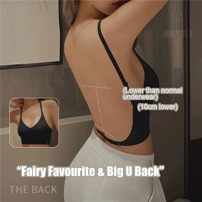 A black camisole with a deep U-shaped open back design and thin adjustable straps, shown from a side and back view on a person wearing white bottoms.