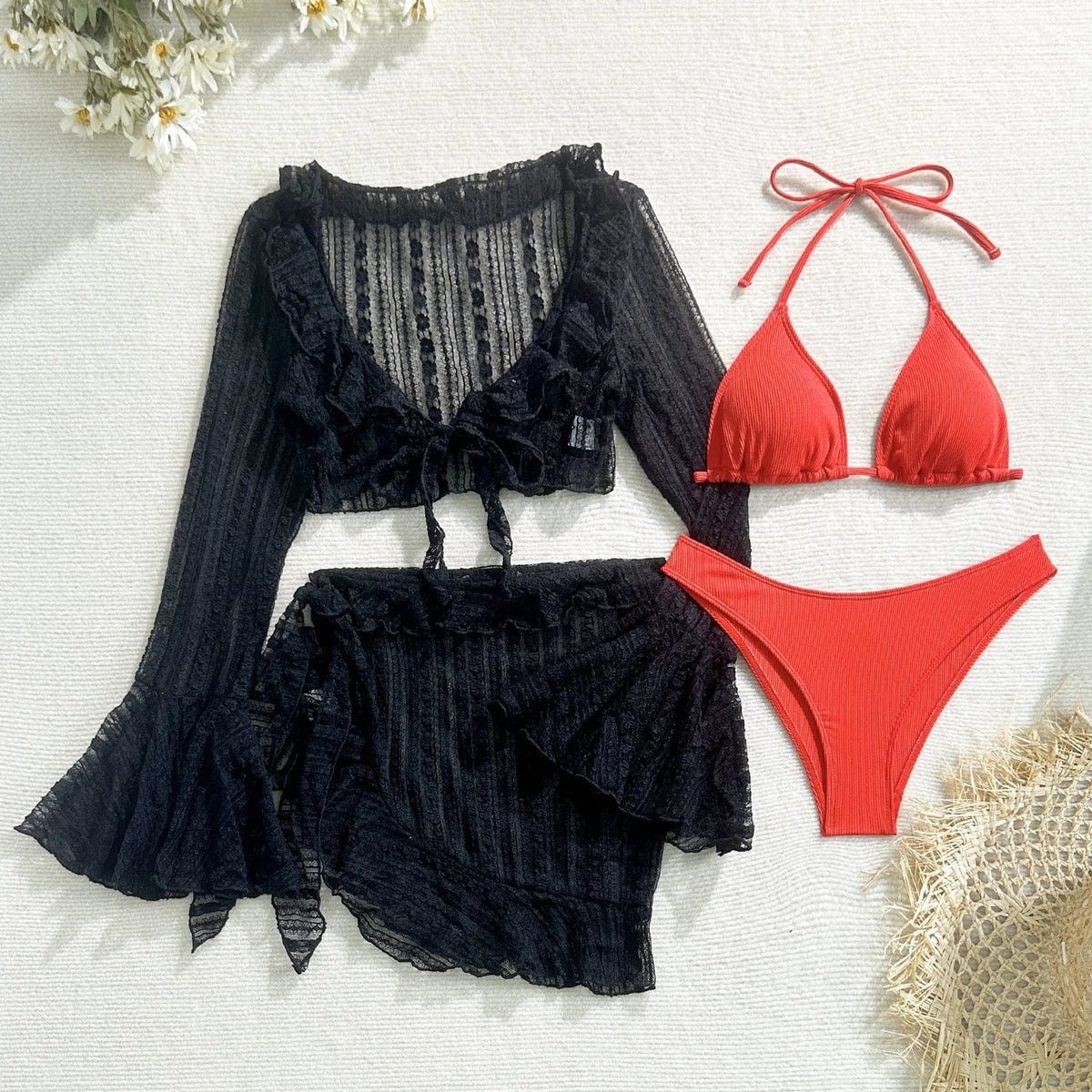 A set including a black long-sleeved, ruffled cover-up top and matching mini skirt, displayed alongside a red ribbed triangle bikini set on a white textured background.