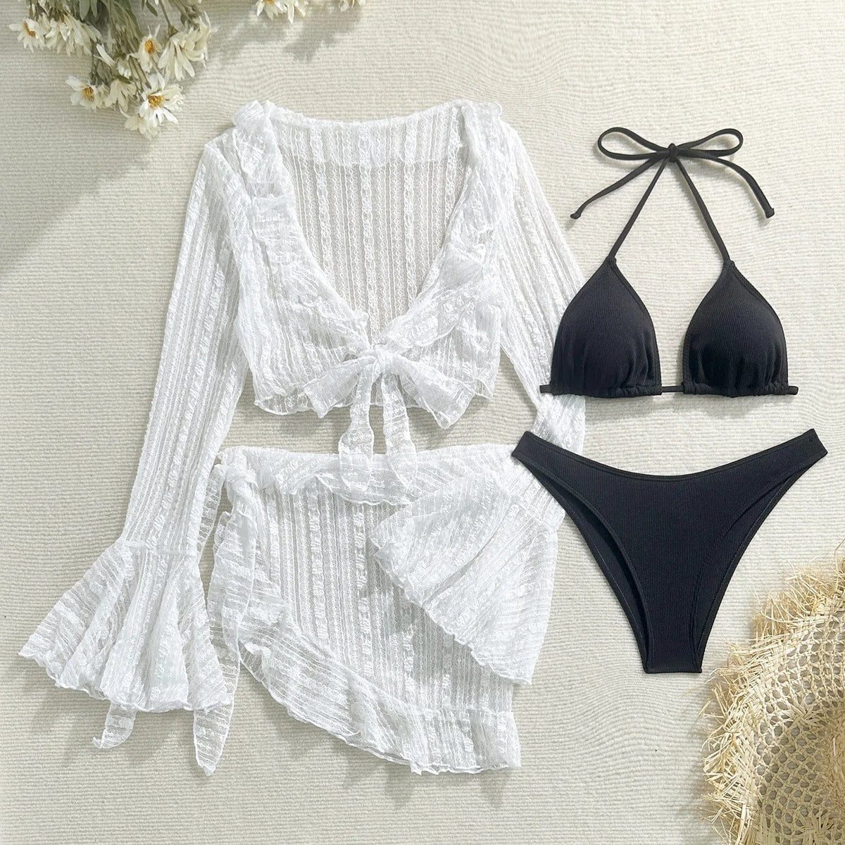 A black bikini set consisting of a triangle top and high-cut bottoms, displayed alongside a sheer white long-sleeved tie-front top and a matching ruffled mini skirt.