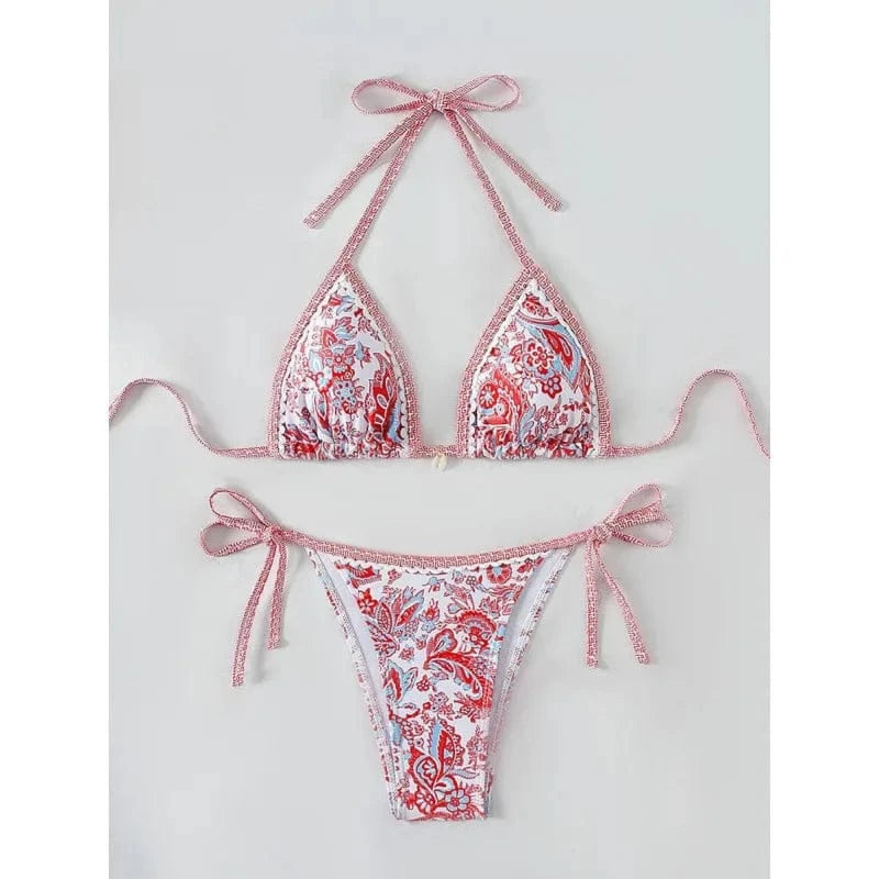 A two-piece bikini set with a vibrant red and blue paisley floral print, featuring a triangle top with tie-back straps and matching side-tie bikini bottoms.