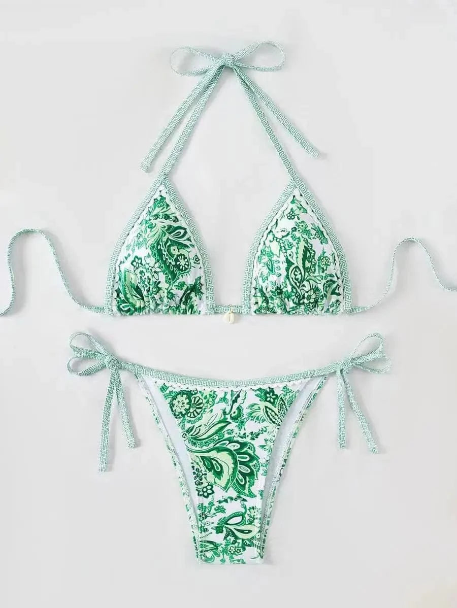 A two-piece bikini set featuring a green and white paisley pattern with decorative trim and side-tie detailing on the bottoms.