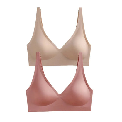 Two seamless wireless bras with V-necklines are shown, one in a light beige and the other in a muted pink, each featuring adjustable shoulder straps.