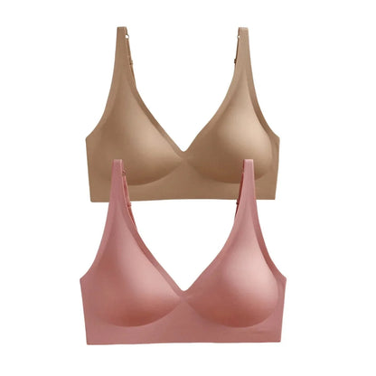 Two seamless wireless bras in nude and dusty pink with deep V-necklines and adjustable shoulder straps arranged vertically against a white background.