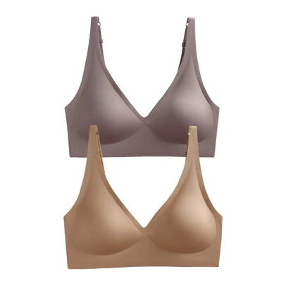 Two seamless, V-neck bras with wide straps are layered vertically, one in a soft mauve tone and the other in a light beige shade.