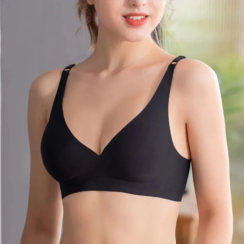 A black wireless bralette with smooth cups and adjustable straps worn by a person.