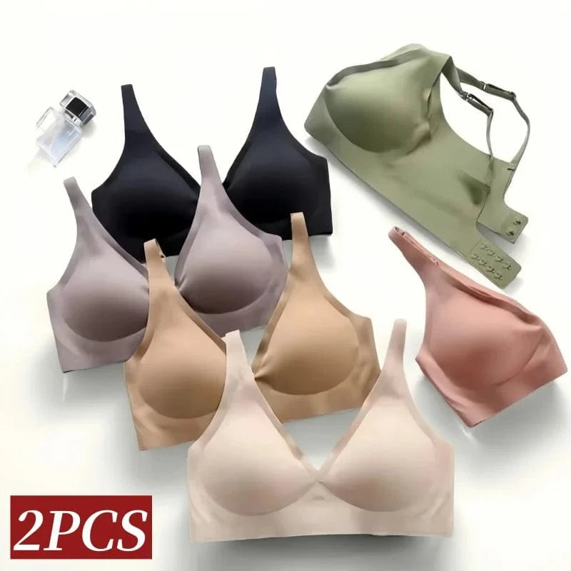 A selection of wireless seamless bras in various neutral shades including black, beige, mauve, and sage green, arranged on a plain background with a small perfume bottle.