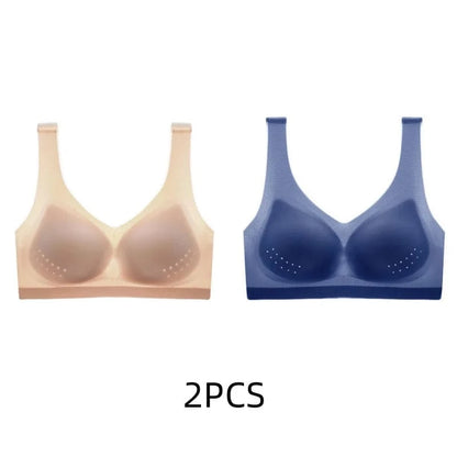 Two seamless sports bras with molded cups and subtle ventilation dots are displayed side-by-side, one in a nude beige color and the other in a dark blue color, with the text 2PCS printed below.