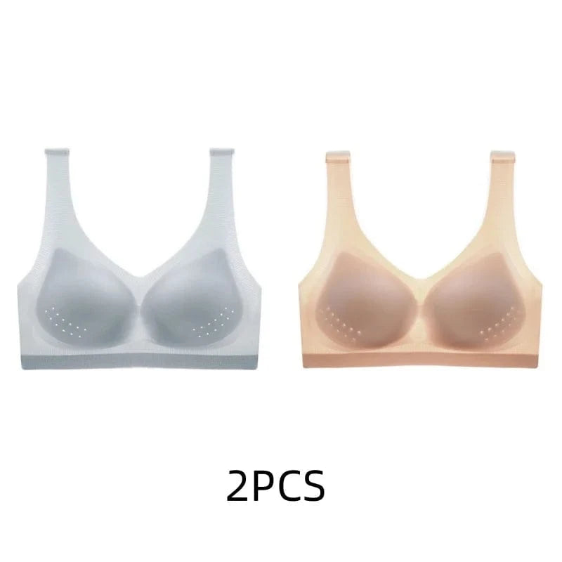 Two seamless sports bras with perforated padding, one in light grey and one in beige, displayed side by side against a white background.