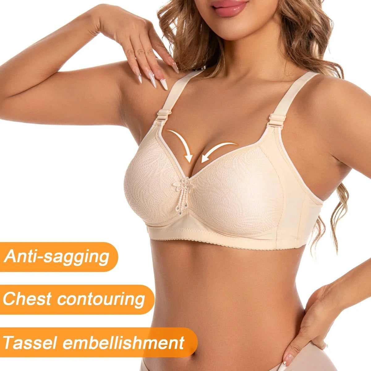 A beige wireless bra with a lace-textured fabric, adjustable straps, and a decorative tassel charm centered between the cups.