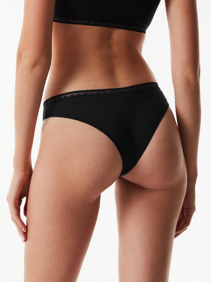 Black bikini-style panties viewed from behind on a person against a plain white background.