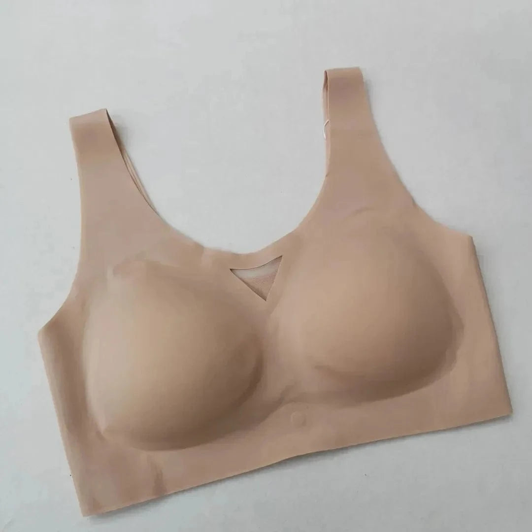A beige seamless wireless lounge bra with molded cups and a small triangular mesh cutout detail at the center neckline set against a plain white background.