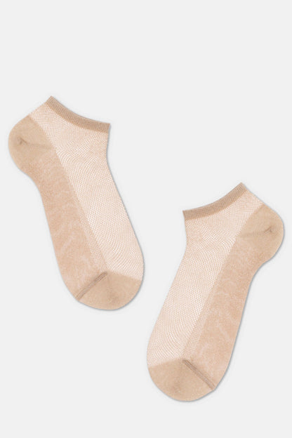 A pair of beige ankle-length socks with a sheer, mesh-like knit texture against a plain light gray background.