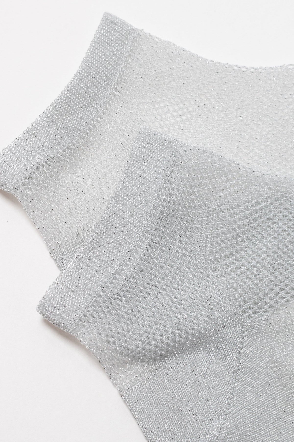 A pair of sheer, metallic silver ankle socks featuring a fine mesh texture against a plain white background.