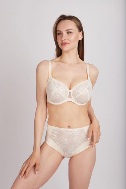 A beige two-piece lingerie set featuring a lace-detailed balconette bra and matching high-waisted briefs worn by a woman against a plain grey background.