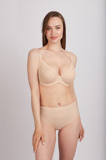 A beige underwire bra and high-waisted briefs worn by a woman posing against a plain grey background.