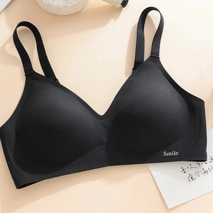 A black wireless bralette with ribbed texture and thin shoulder straps, featuring the word Smile in small silver lettering on the bottom right band.